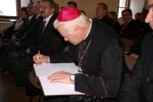 Ksiądz Biskup Adam Szal wpisuje się do księgi pamiątkowej