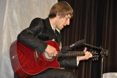 Adrian Sikora - uczeń ZSLiT, podczas recytacji przy akompaniamencie dźwięków gitary.