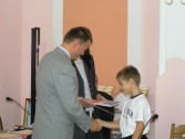 Jakub Hajduk przyjmuje gratulacje od dr Teresy Adamczyk i burmistrza Janusza Dąbrowskiehgo.